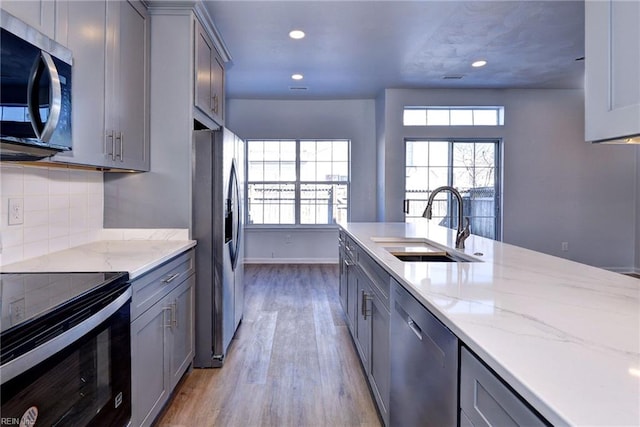 kitchen with appliances with stainless steel finishes, gray cabinets, and a sink