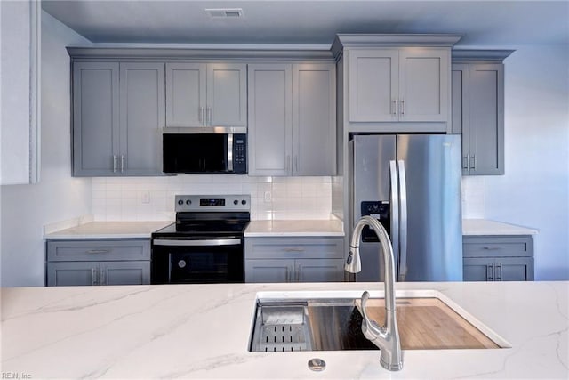 kitchen with appliances with stainless steel finishes and gray cabinetry