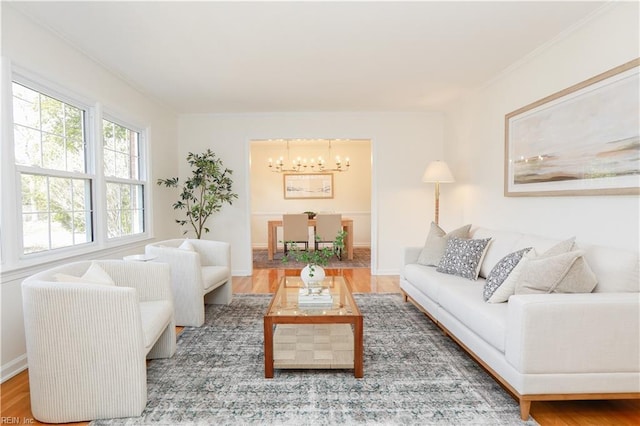 living area featuring an inviting chandelier, baseboards, and wood finished floors