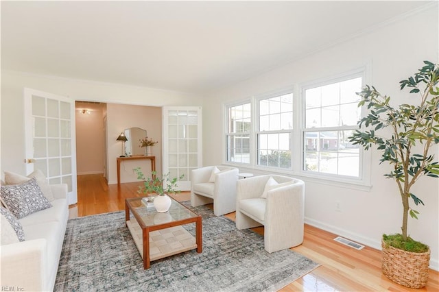 living area with visible vents, baseboards, and wood finished floors