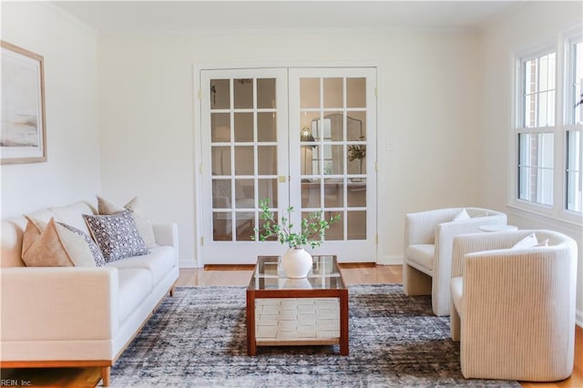 living room with plenty of natural light, ornamental molding, and wood finished floors