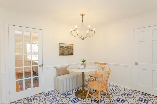 dining area featuring a notable chandelier, baseboards, and crown molding