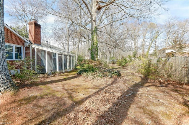 view of yard with a sunroom and fence