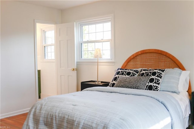 bedroom with wood finished floors and baseboards