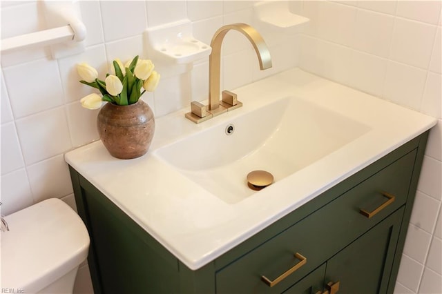 bathroom with toilet, tile walls, and vanity