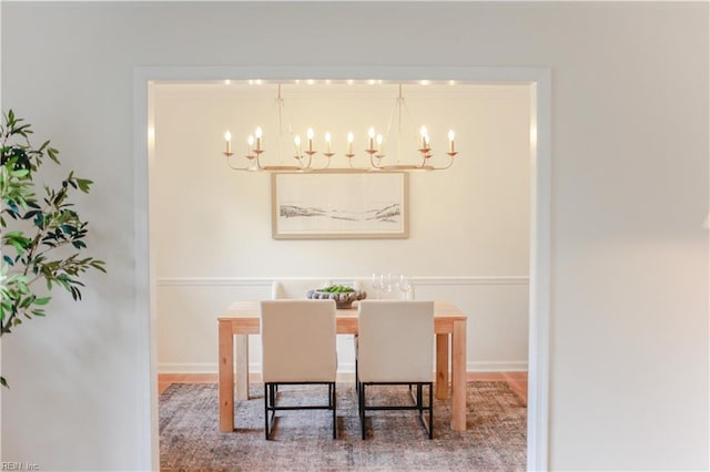 dining area featuring baseboards and a notable chandelier