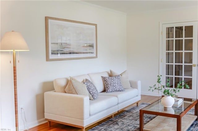 living room with ornamental molding, wood finished floors, and baseboards