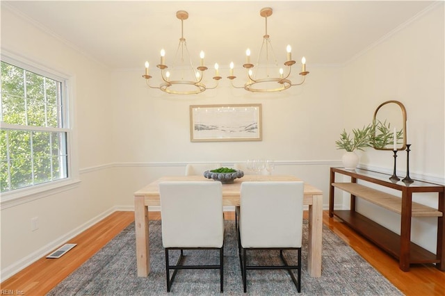 dining space with a chandelier, crown molding, and dark wood finished floors