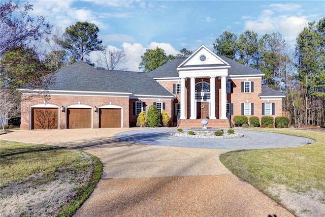 neoclassical / greek revival house with a garage, concrete driveway, and a front yard