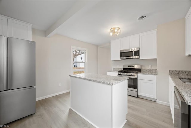 kitchen with visible vents, light stone counters, appliances with stainless steel finishes, and white cabinetry