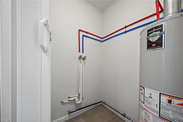 laundry room featuring laundry area, water heater, wood finished floors, and hookup for a washing machine