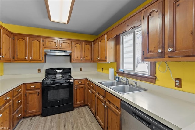 kitchen featuring under cabinet range hood, a sink, stainless steel dishwasher, brown cabinetry, and gas stove