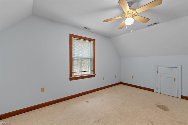 additional living space featuring lofted ceiling, baseboards, visible vents, and light colored carpet