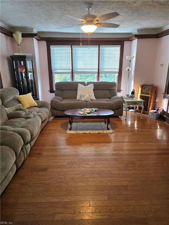 living area featuring crown molding, a textured ceiling, ceiling fan, and wood finished floors