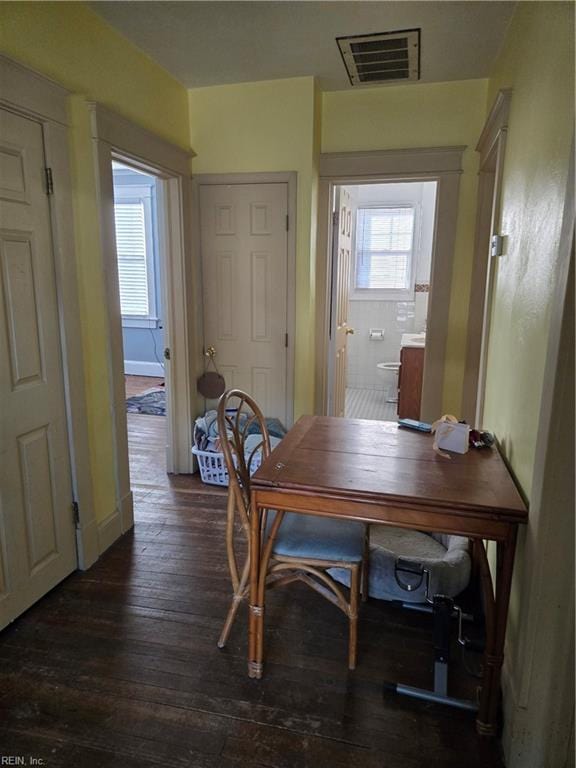 dining room featuring baseboards, dark wood-type flooring, visible vents, and a healthy amount of sunlight