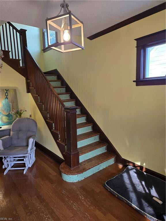 stairs featuring crown molding, baseboards, and wood finished floors