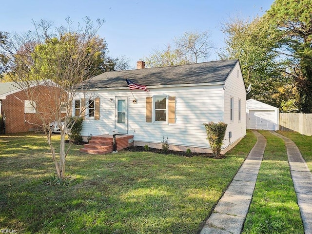 bungalow-style home featuring an outbuilding, a chimney, a front yard, and a detached garage