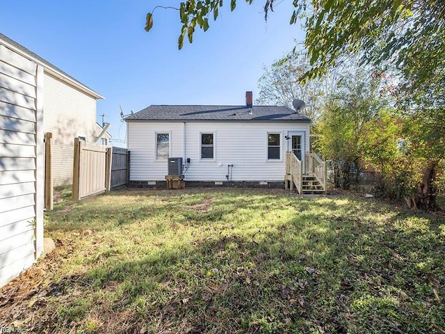 rear view of property featuring a yard, fence, and a chimney