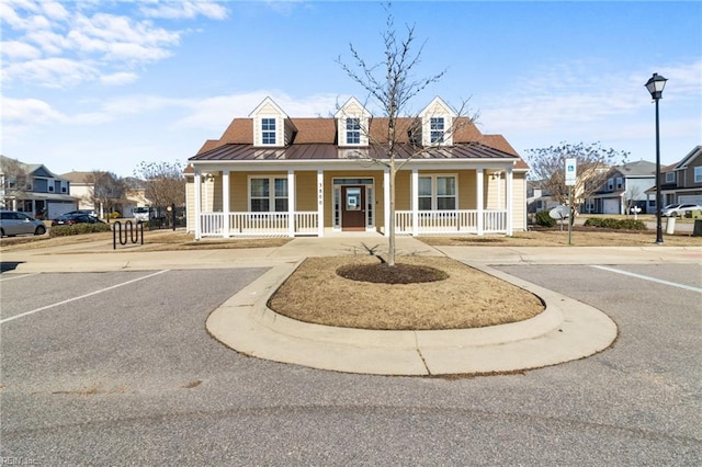 view of front of property with covered porch, metal roof, a standing seam roof, and a residential view