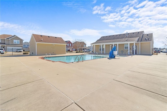 pool with a residential view, fence, and a patio