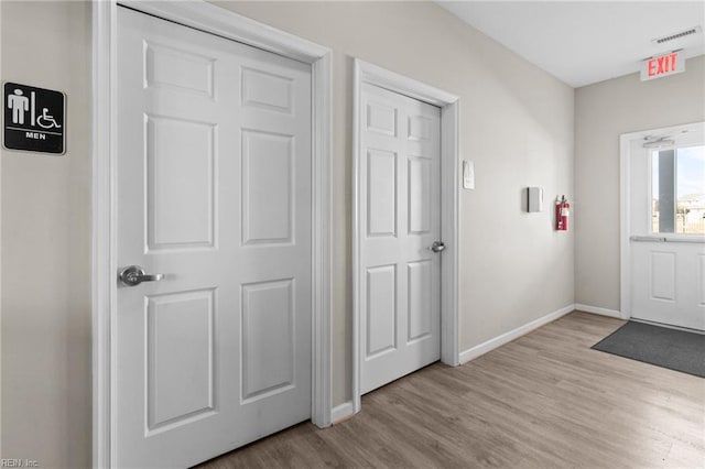 foyer with light wood-type flooring, baseboards, and visible vents