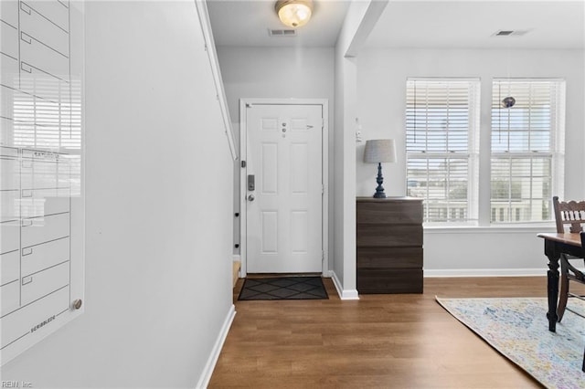 entrance foyer with baseboards, visible vents, and wood finished floors