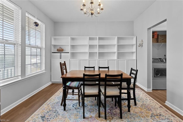 dining area featuring dark wood-style floors, baseboards, a chandelier, and washer and dryer