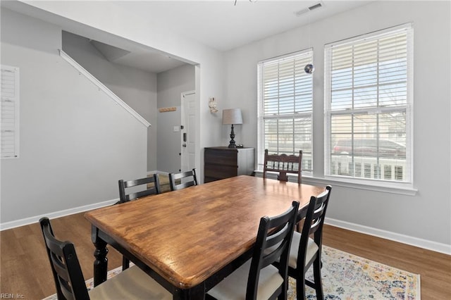 dining room featuring wood finished floors, visible vents, and baseboards