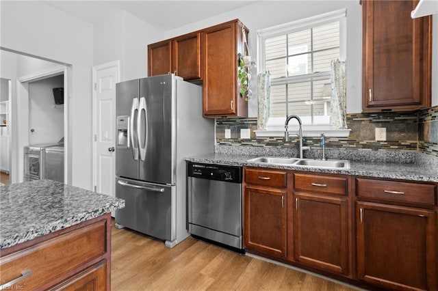 kitchen featuring dark stone counters, stainless steel appliances, and a sink