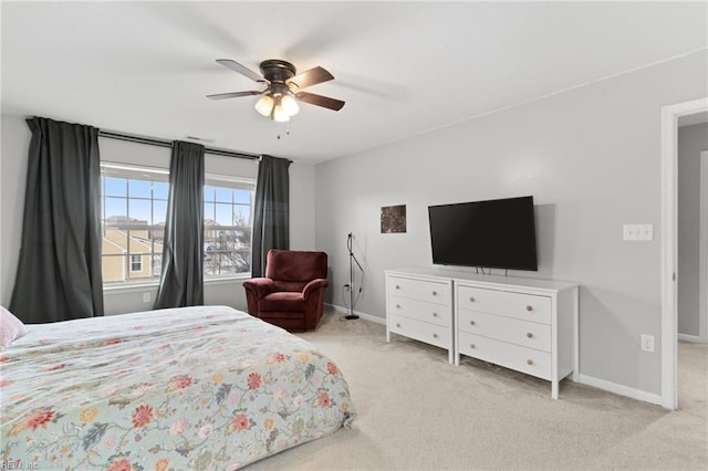 bedroom featuring a ceiling fan, light colored carpet, and baseboards