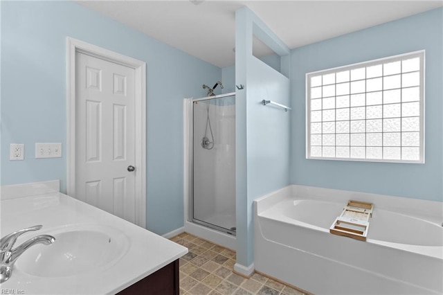 bathroom with a shower stall, baseboards, a bath, and vanity