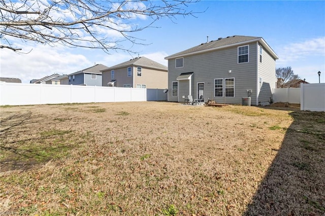 back of house featuring cooling unit, a fenced backyard, and a yard