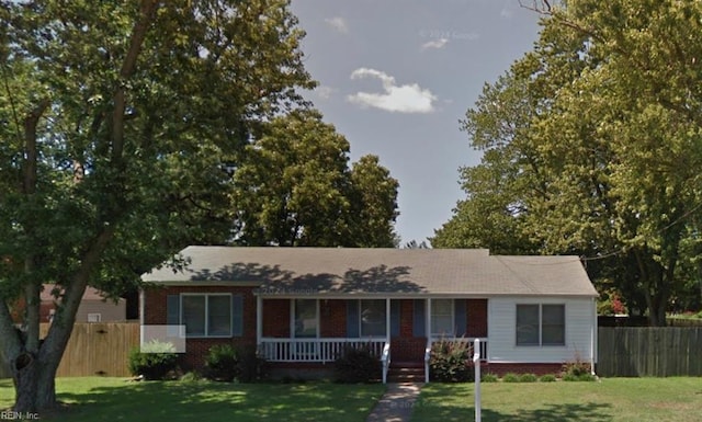 single story home with covered porch, fence, a front lawn, and brick siding