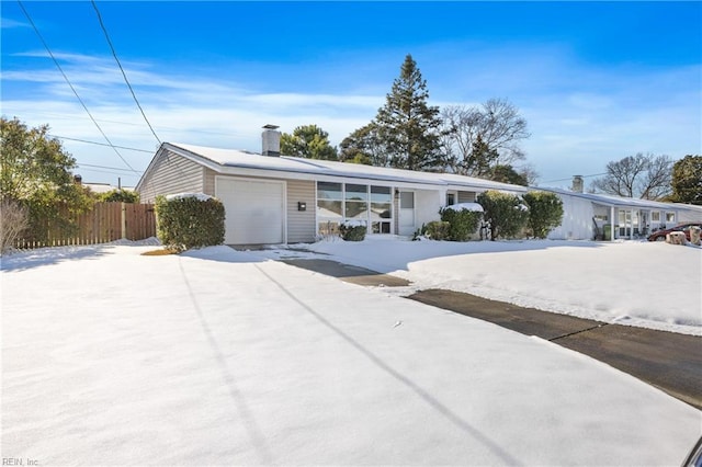 ranch-style house featuring fence and an attached garage