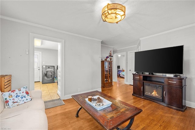 living room featuring ornamental molding, light wood finished floors, and washer / dryer