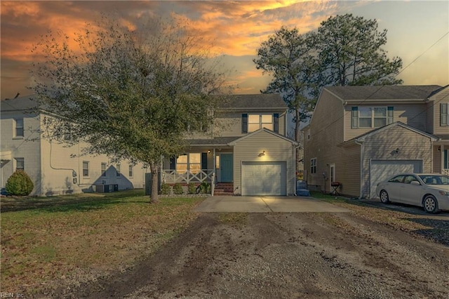 view of front of home with driveway, a garage, a front lawn, and a porch