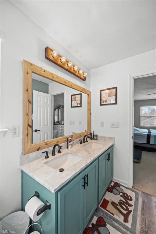 bathroom featuring double vanity, baseboards, and a sink