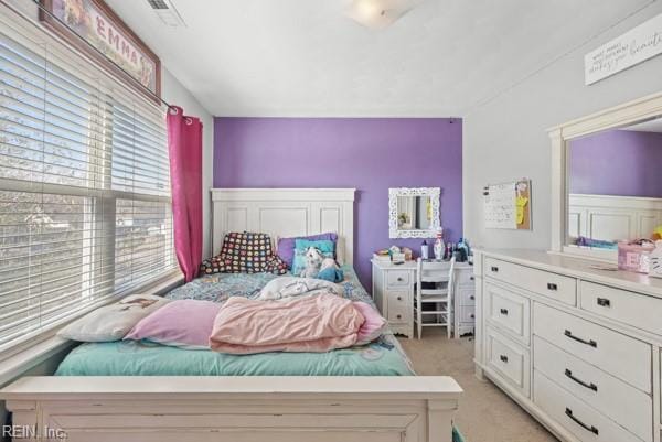 bedroom with lofted ceiling, light carpet, and visible vents