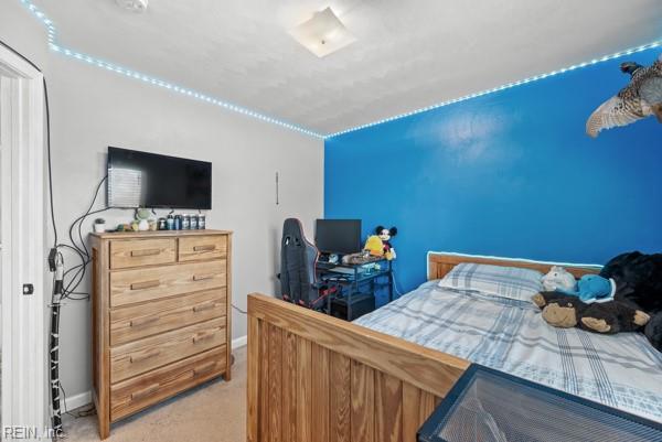 bedroom featuring baseboards and light colored carpet