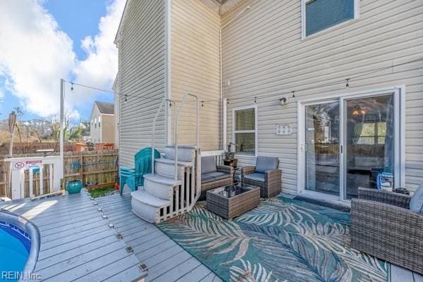 wooden terrace featuring an outdoor hangout area and fence