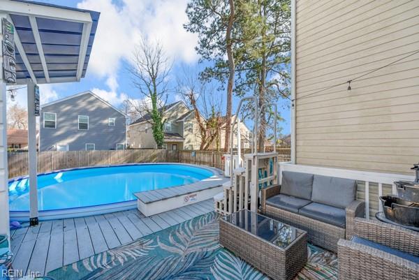 view of swimming pool featuring a fenced in pool, outdoor lounge area, and fence