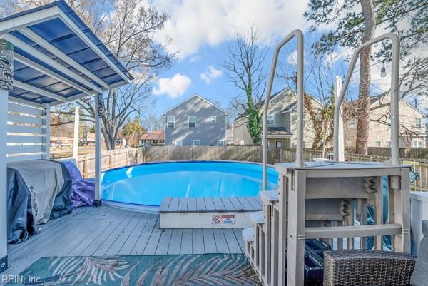 view of pool featuring outdoor dry bar, a wooden deck, fence, and a fenced in pool