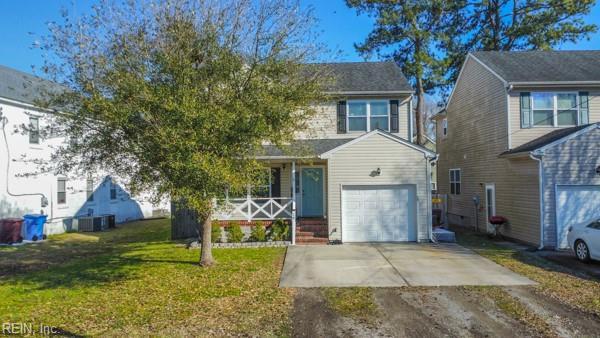 view of front of house featuring a garage, driveway, a porch, and a front yard