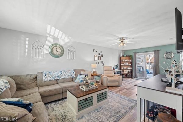 living area with light wood-style floors and a ceiling fan