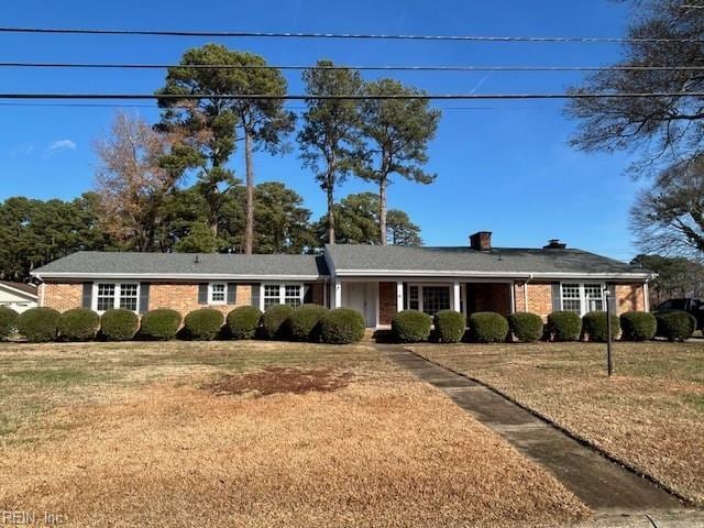 ranch-style house featuring brick siding and a front yard