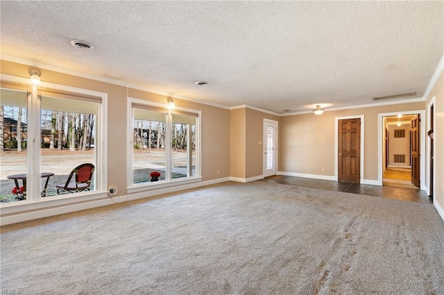 unfurnished room featuring a textured ceiling, dark colored carpet, visible vents, and crown molding