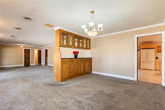 spare room featuring ornamental molding, visible vents, and light colored carpet