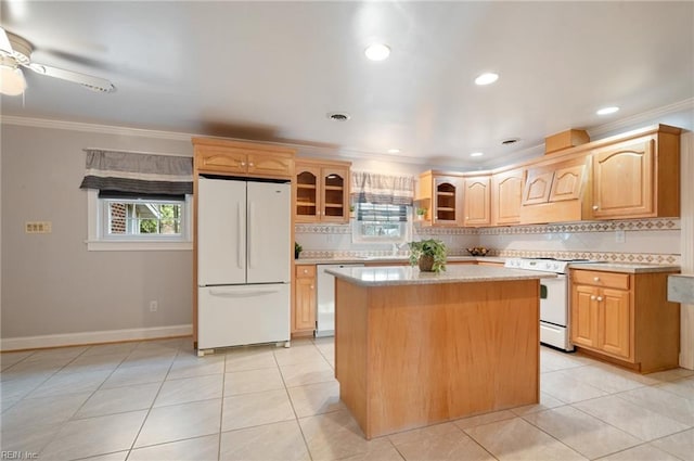 kitchen featuring white appliances, light countertops, a center island, glass insert cabinets, and crown molding