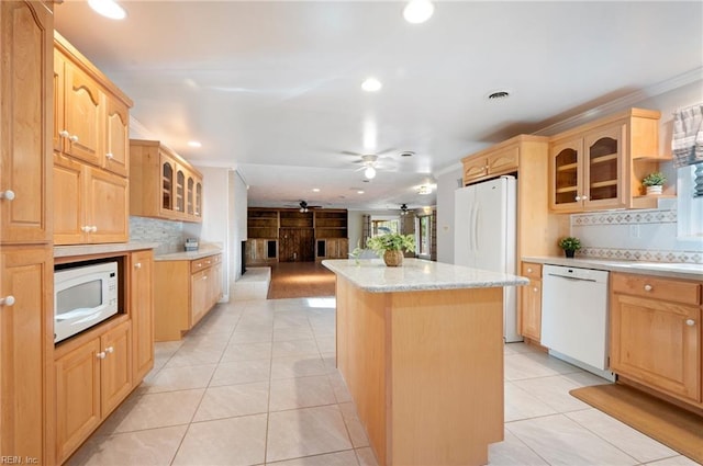 kitchen featuring glass insert cabinets, a center island, white appliances, and light tile patterned floors