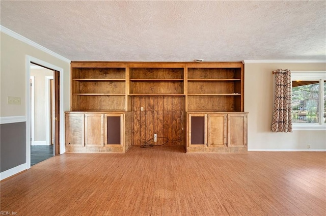 unfurnished living room with built in shelves, a textured ceiling, baseboards, and wood finished floors